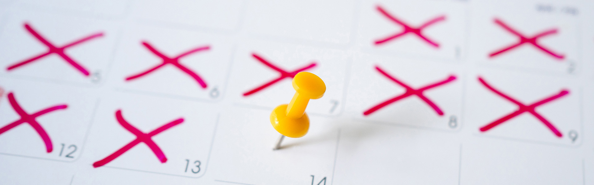 Kalender mit gelber Pinnadel an einem Datum