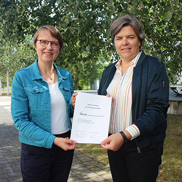 Katrin Weke und Anja Reineke halten den unterzeichneten Letter of Intent gemeinsam in die Kamera
