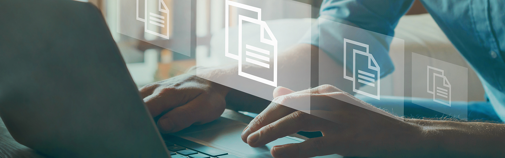 Person tippt auf Laptop und Blätter steigen auf