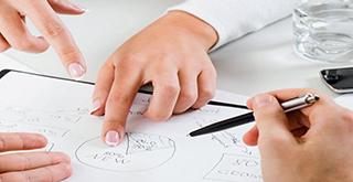 Hände, Stift und Notzien auf Besprechungstisch beim Arbeiten