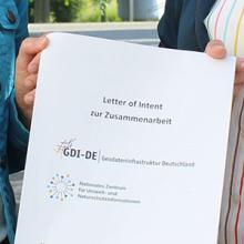 Deckblatt des Letter of Intent wird von 2 Personen hochgehalten